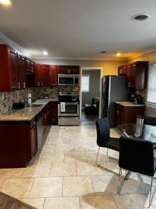 a large kitchen with wooden cabinets and appliances at Modern 3 Bedroom Ranch House in Newark