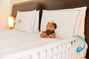 a teddy bear sitting on top of a bed at Hotel Atlantic Hamburg, Autograph Collection in Hamburg