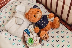 a brown teddy bear sitting in a crib with toys at Hotel Atlantic Hamburg, Autograph Collection in Hamburg