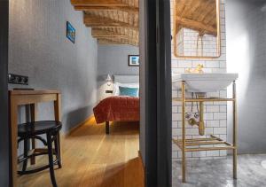 a bathroom with a sink and a bed in a room at Langley Hotel Gustavia in Chamonix