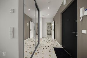 a hallway with a door and a floor with leaves at Bright 2BR with Private EV Parking, workspace, AC in Kaunas