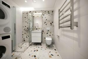 a white bathroom with a toilet and a shower at Bright 2BR with Private EV Parking, workspace, AC in Kaunas +22 photos