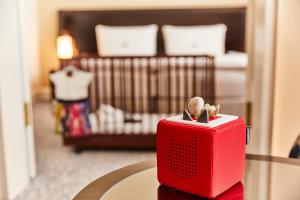 a red toaster sitting on a table in a bedroom at Hotel Atlantic Hamburg, Autograph Collection in Hamburg
