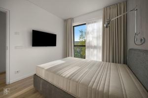 a bedroom with a bed and a large window at Bright 2BR with Private EV Parking, workspace, AC in Kaunas