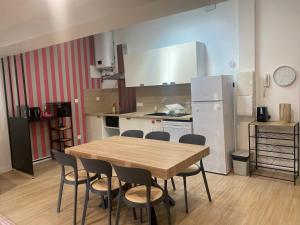 a kitchen with a wooden table and chairs in it at Le grand Castel in Castelnaudary