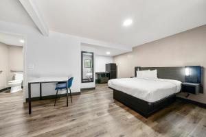 卡罗尔顿Southern Suites Carrollton的一间卧室，配有一张床、一张书桌和一个水槽