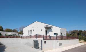 a white building with a fence around it at Villa Mateo 2 in Ližnjan