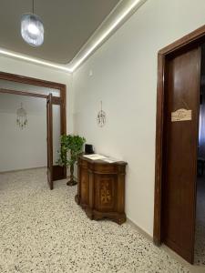 a hallway with a wooden table and a door at B&B Domus Flora in Reggio Calabria