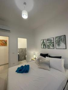a white bed with two blue towels on it at Nerea in San Vito lo Capo