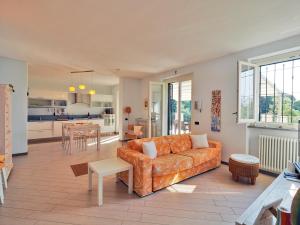 un salon avec un canapé orange et une cuisine dans l'établissement Villa Patrizia, à Lerici