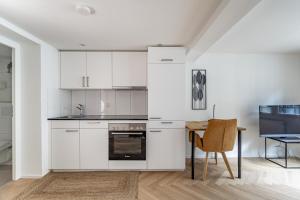 a kitchen with white cabinets and a table at Apartments Multergasse in St. Gallen