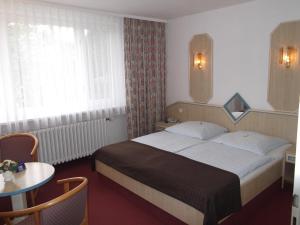 ein Hotelzimmer mit einem Bett und einem Tisch in der Unterkunft Seehotel Ichlim in Sewekow