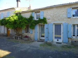 a house with blue shutters on the side of it at location thezacaise in Thézac