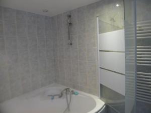 a bathroom with a bath tub and a shower at location thezacaise in Thézac +8 photos