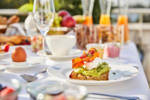 a white table with a plate of food on it at Hotel Atlantic Hamburg, Autograph Collection in Hamburg