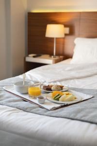 uma bandeja de comida de pequeno-almoço numa cama em Hotel Navarras em Amarante