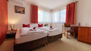 a bedroom with two beds with red curtains at Brasserka in Nitra +18 photos