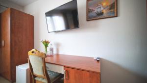 a room with a desk with a tv on a wall at Brasserka in Nitra