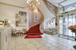 a room with a staircase with a red rug at Brit Hotel Bristol Montbéliard Centre in Montbéliard