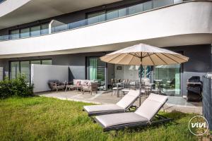 eine Terrasse mit Liegestühlen und einem Sonnenschirm in der Unterkunft ViVi Homes - Higueron Premium Wellness, Sauna, Pool & Hot tub in Fuengirola + 20 Fotos