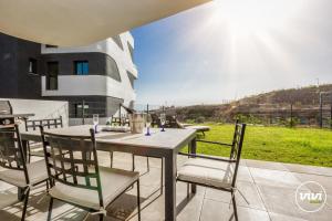 einen Tisch und Stühle auf einer Terrasse mit Aussicht in der Unterkunft ViVi Homes - Higueron Premium Wellness, Sauna, Pool & Hot tub in Fuengirola