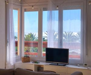 a living room with a large window with a flat screen tv at Apartment Vicente in Vilanova i la Geltrú