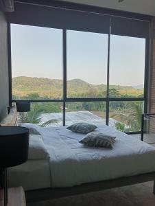 a bedroom with a large bed and a large window at Sky Lofts Phuket in Nai Yang Beach +38 photos