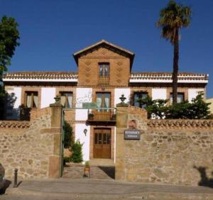 ラ・アドラダにあるPosada Villa Mariaのヤシの木が目の前にある建物