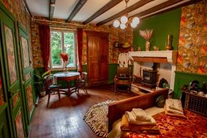 a living room with green walls and a fireplace at Nana Mac Chambre D'hôtes in Limalonges