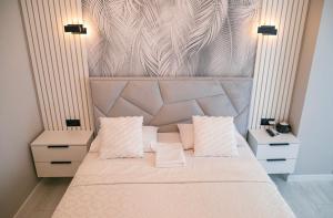a bedroom with a large bed with two pillows at Lux Apartament Center in Chişinău