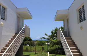 Una vista desde el exterior de un edificio blanco con escaleras. en Le Flamboyant de Delna, en Saint-François