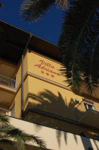 a sign on the side of a building with a palm tree at Hotel Villa Adriana in Monterosso al Mare