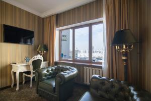 a hotel room with a couch and a table and a window at Royal Olympic Hotel in Kyiv