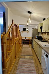 a kitchen with a staircase and a kitchen with a table at Casa linistita Ilie in Păltineni