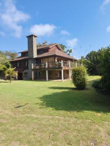 a large house with a chimney on top of a yard at Kwezi Cottage at The Great Rift Valley Lodge & Golf Resort Naivasha in Naivasha