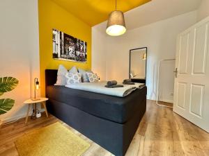 a bedroom with a blue bed with a yellow wall at 250m Rhein - ruhig - Hbf - Boxspringbett - K-111-S in Koblenz