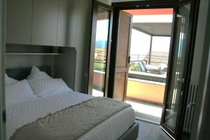 a bedroom with a white bed and a balcony at ferienwohnungkarlena in Cerro Lago Maggiore