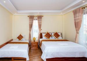 ein Schlafzimmer mit zwei Betten und einem Fenster in der Unterkunft Mai Place Homestay in Ninh Bình