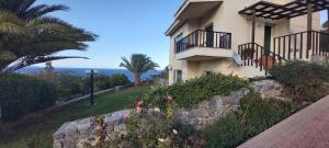a house with a stone wall next to the ocean at Βίλα Στέλλα Ιωάννης in Agia Pelagia