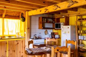 a kitchen with a refrigerator and a table in it at Cabaña Naxara III in Villa La Angostura