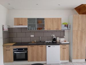 a kitchen with wooden cabinets and a white appliance at Appart Maison de ville in Bourges +4 photos