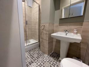 a bathroom with a sink and a shower and a toilet at Central Hotel in Norwich