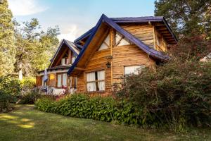 a log cabin with a blue roof at Cabaña Naxara III in Villa La Angostura