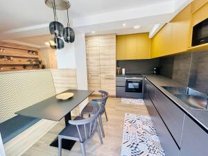 a kitchen with a table and chairs and a kitchen with yellow cabinets at Villa Nogueira in Vilagarcia de Arousa