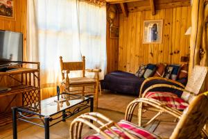 a living room with a couch and chairs and a tv at Cabaña Naxara III in Villa La Angostura +12 photos
