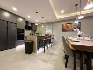 une cuisine et une salle à manger avec une table et des chaises dans l'établissement Super Luxury 3 Bedroom Private Pool Villa with Jacuzzi, Near 711, 10 minutes to Walking Street and Pattaya Beach - MT6, à Pattaya