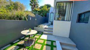 a small patio with a table and chairs on a house at Somerset-West PRIME SPOT- Solar Powered! in Cape Town