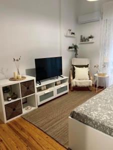 a living room with a television and a white cabinet at Central Comfort Guesthouse in Larisa