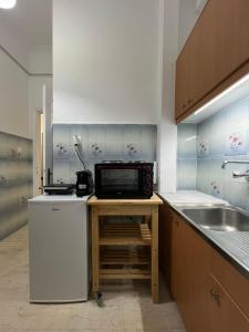 a kitchen with a counter with a microwave and a sink at Central Comfort Guesthouse in Larisa