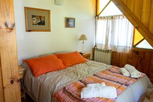 a bedroom with a bed with two towels on it at Cabañas Naxara in Villa La Angostura